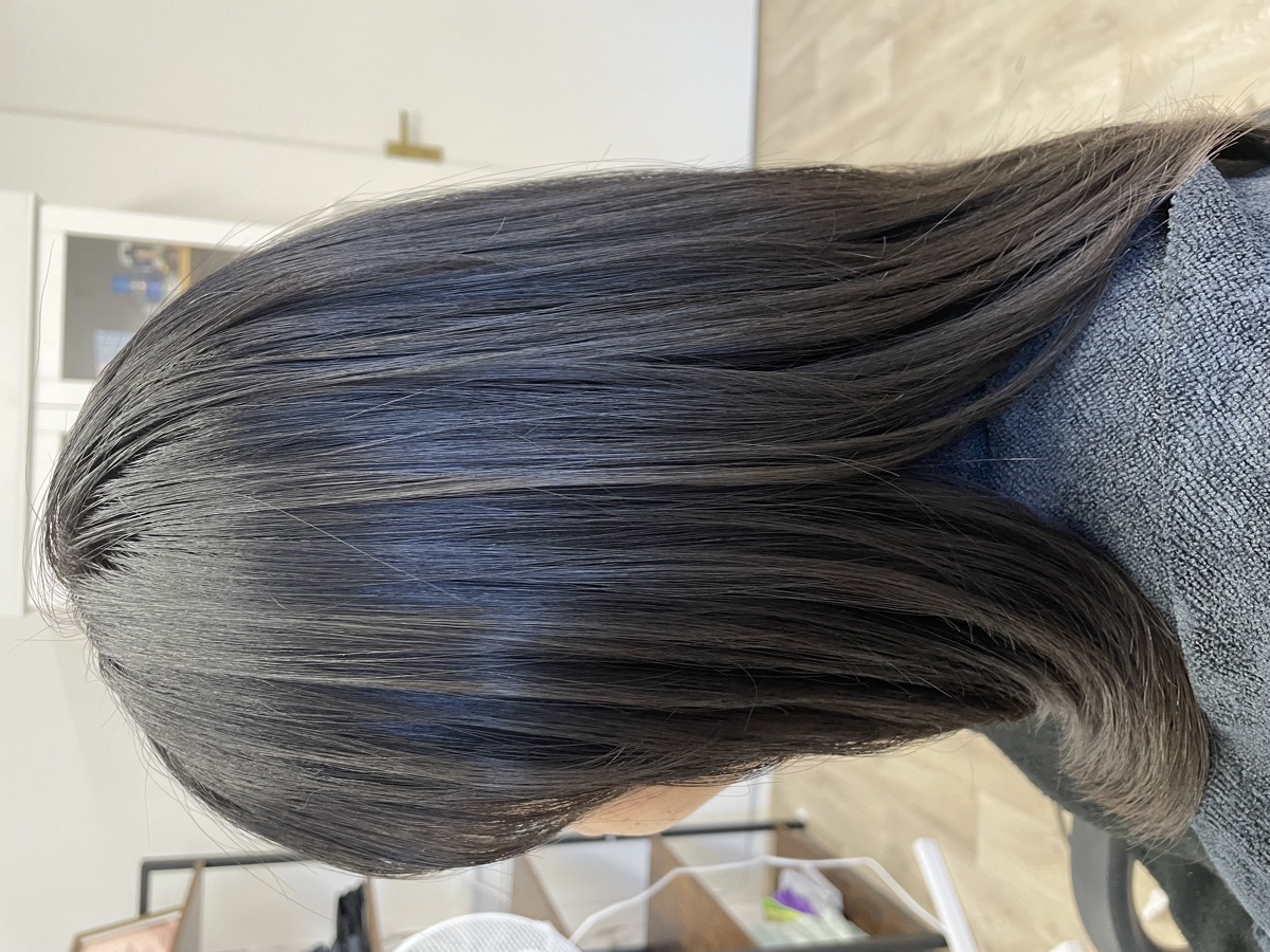 Shoulder-length dark hair cut in layers with a high-shine finish