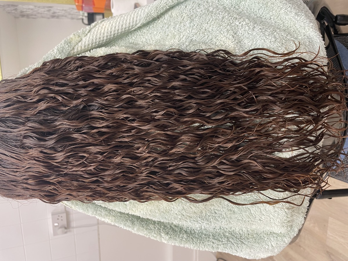 Very long hair set in uniform soft waves after a perm